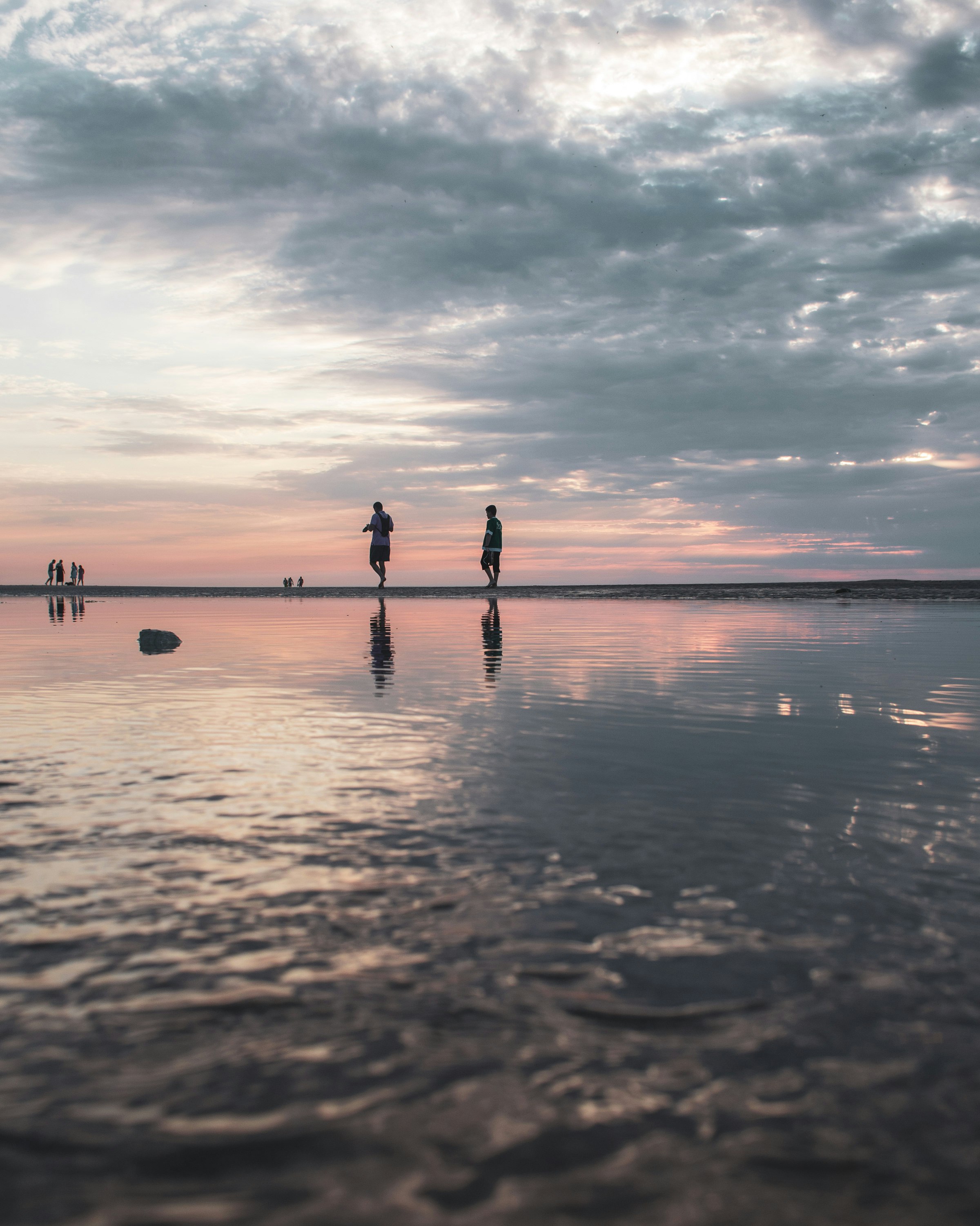 silhouette of 2 person walking on beach during sunset